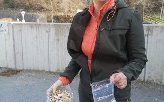 Frau sammelt Zigarettenstummel