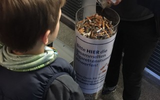 Zigarettenstummel in Behälter füllen