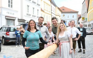 Gruppenfoto zwischen liegenden Maibaum