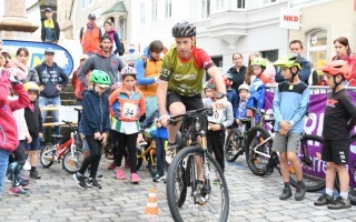 Kinder im Halbkreis um Radlfahrer